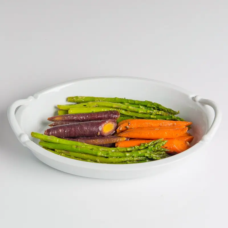 Roasted asparagus and rainbow carrots in a white dish