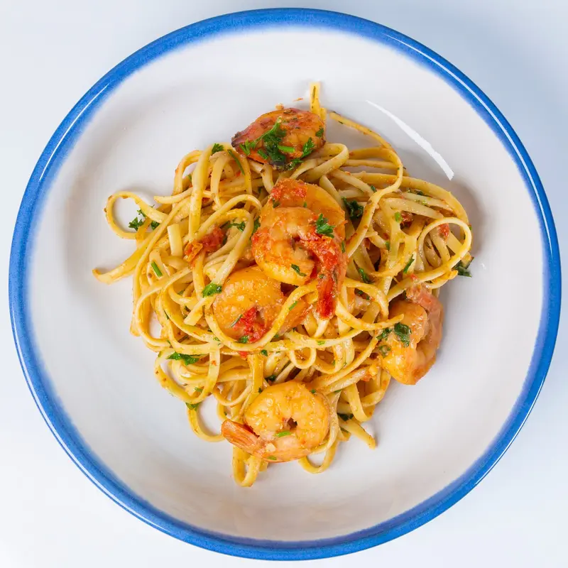 Spicy shrimp linguine in a blue-rimmed bowl
